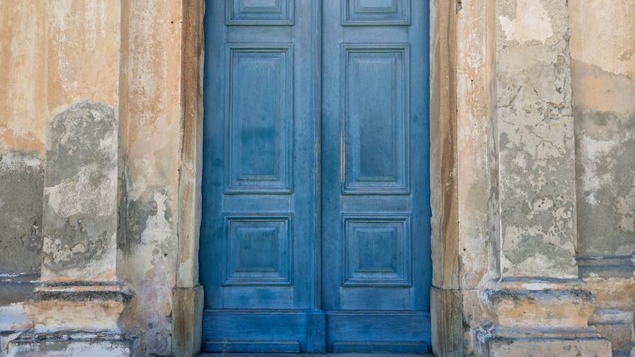 blue wooden door on beige concrete building